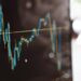 Detailed view of financial trading graphs on a monitor, illustrating stock market trends.